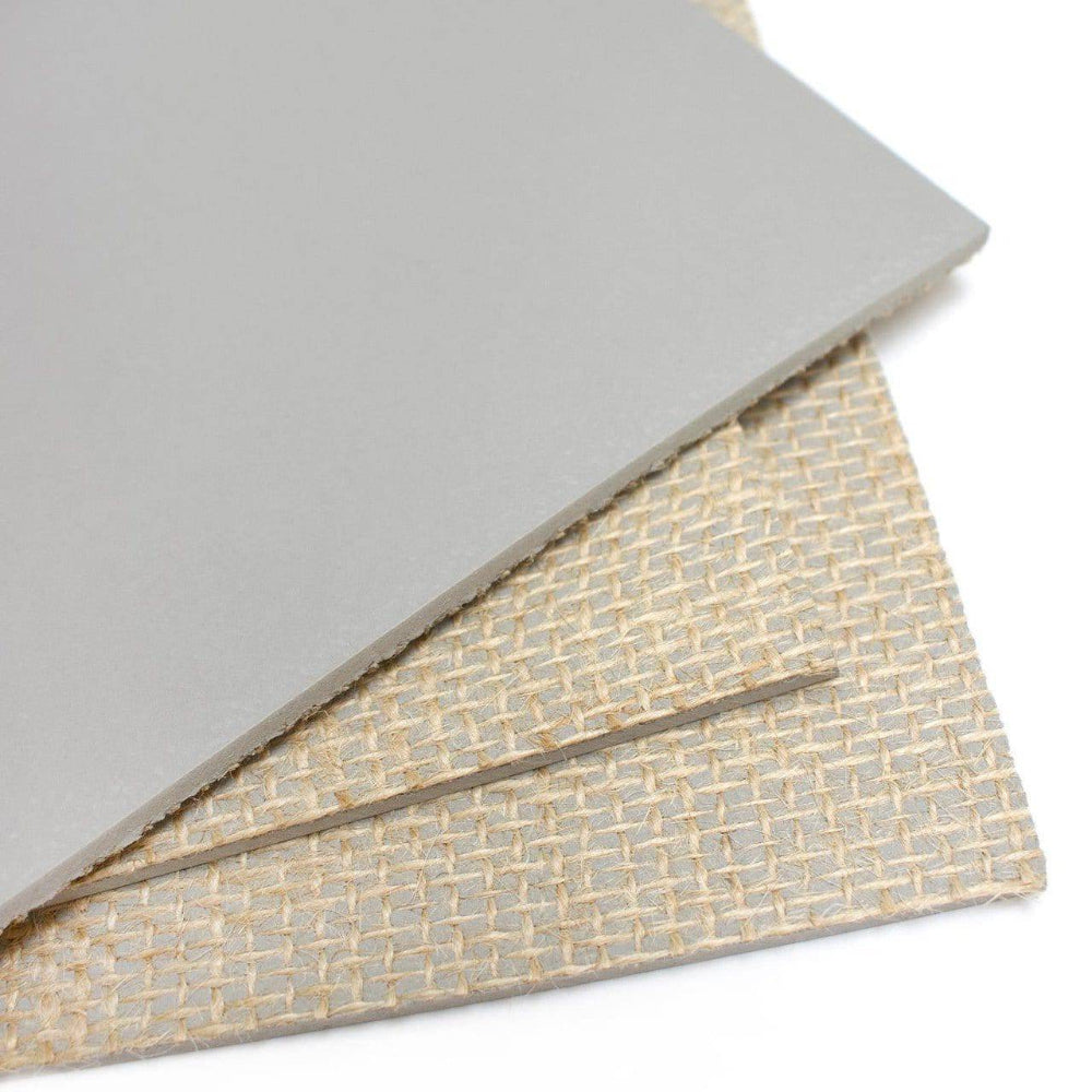 Two sheets of material, one plain gray and one with a textured pattern, on a white background.