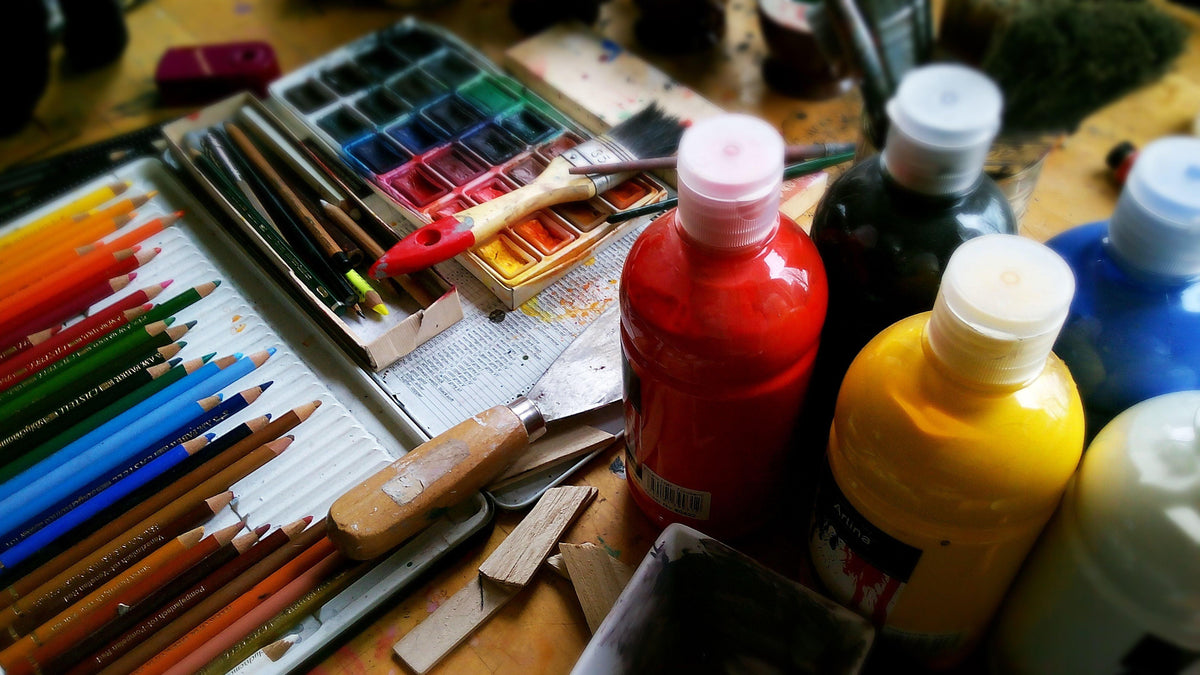 acrylic paints with watercolours and colour pencils in a table